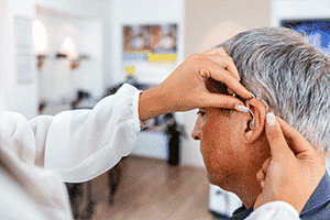 A hearing aid fitting for a mature white man at an audiologist near me